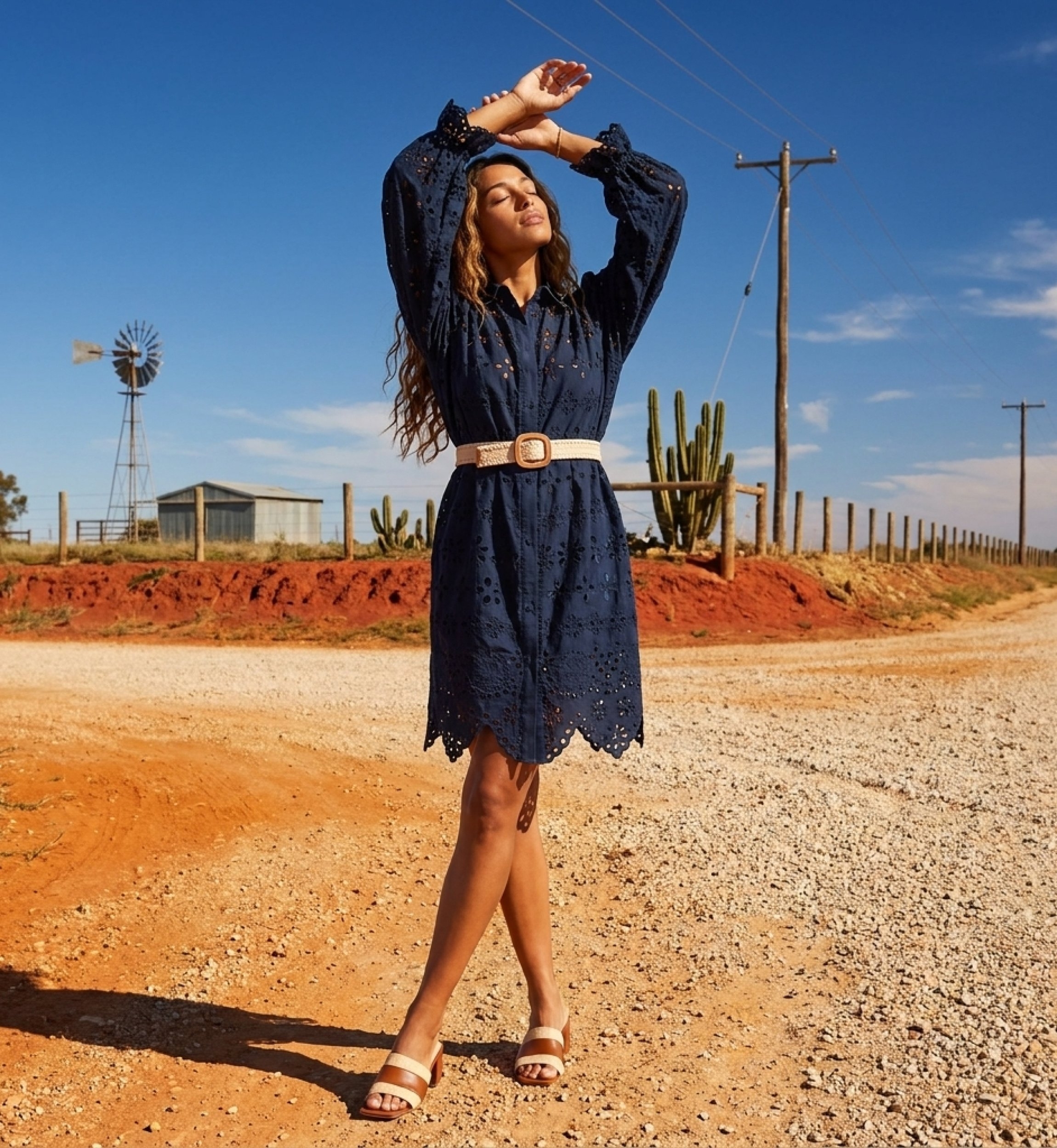Short navy blue dress on model with arms overhead, showcasing fitted bodice and flowy skirt.