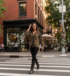 Blusa nera ampia con stampa leopardata oro e bianco, scollo a balze, pompon e nappe, stile casual esterno.