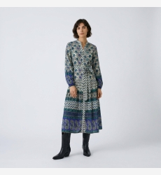 Vestido midi manga longa creme, azul e verde, padrões geométricos florais, cintura com laço, saia em camadas.