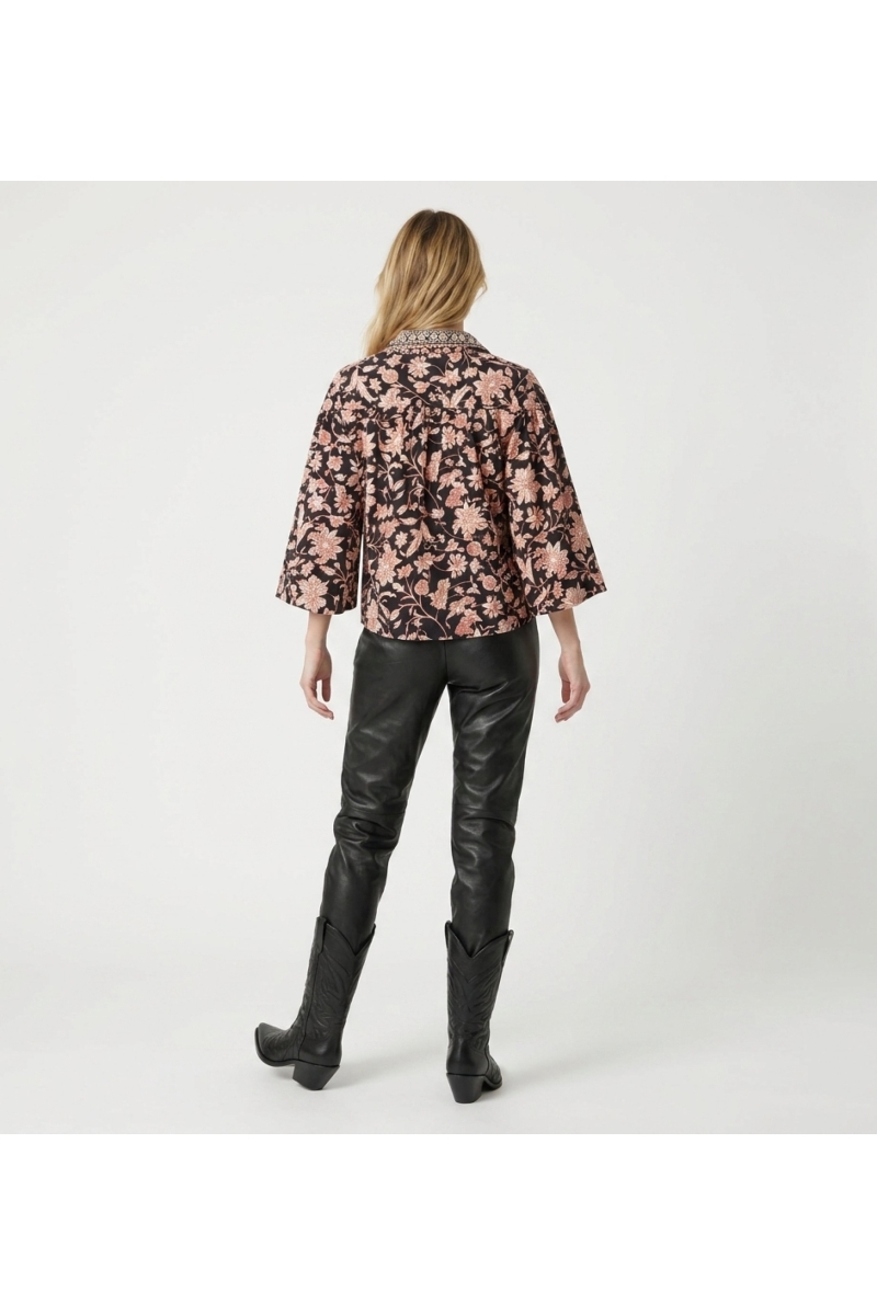 Blusa preta manga longa floral, estampa creme e ferrugem, gola, punhos com babados, tecido leve, vista traseira.