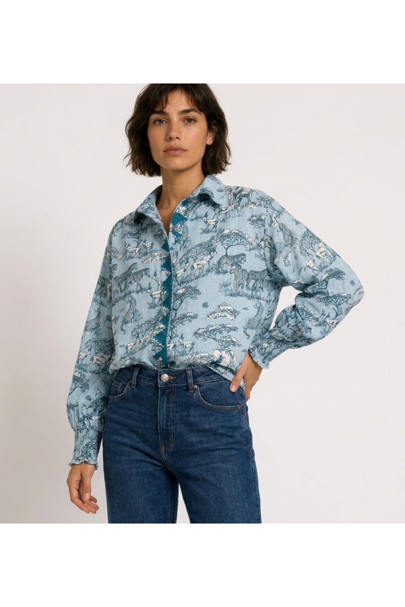 Camisa azul claro de manga comprida com botões, estampa de animais safari azul escuro e branco, mangas bufantes, punhos franzido