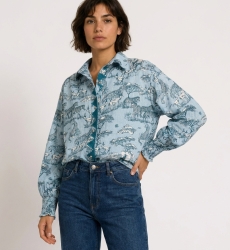 Camicia azzurra a maniche lunghe con bottoni, stampa animali safari blu scuro e bianca, maniche a sbuffo, polsini arricciati.