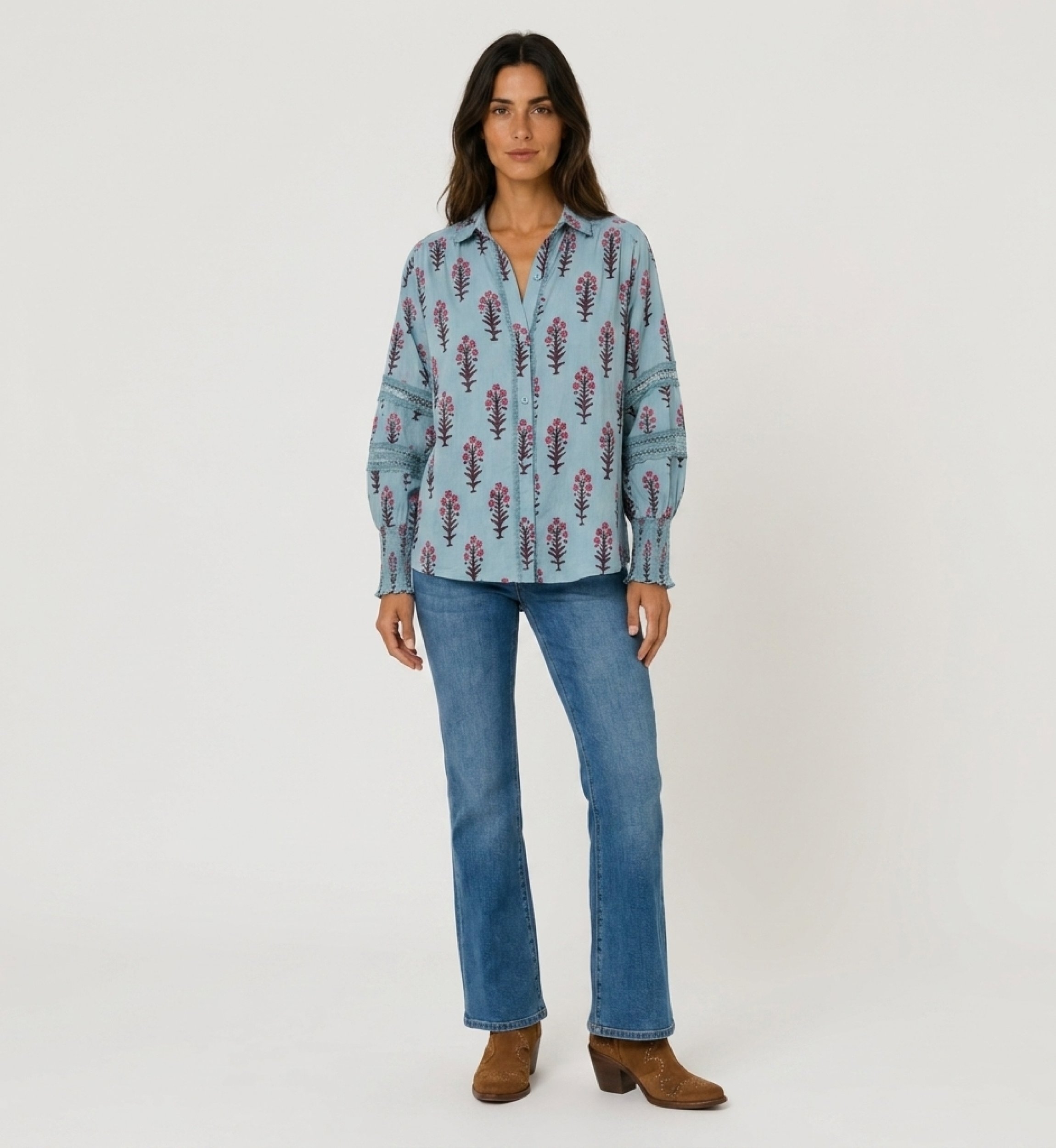 Camisa azul clara floral com botões, decote em V, mangas bufantes com renda e punhos franzidos. Vista frontal.