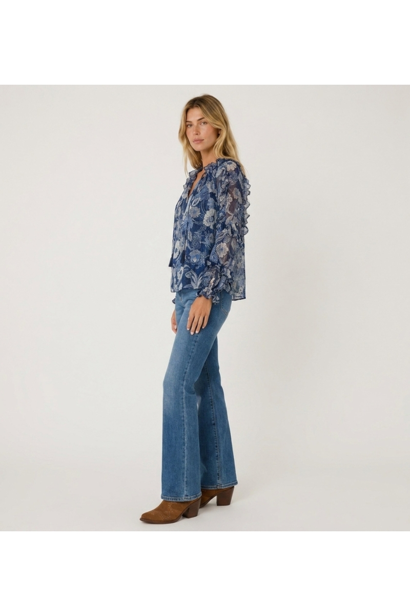 Transparente blaue Langarmbluse mit Blumenmuster, Rüschen an Schultern und Bündchen, Kordelzugausschnitt, Dreiviertelansicht.