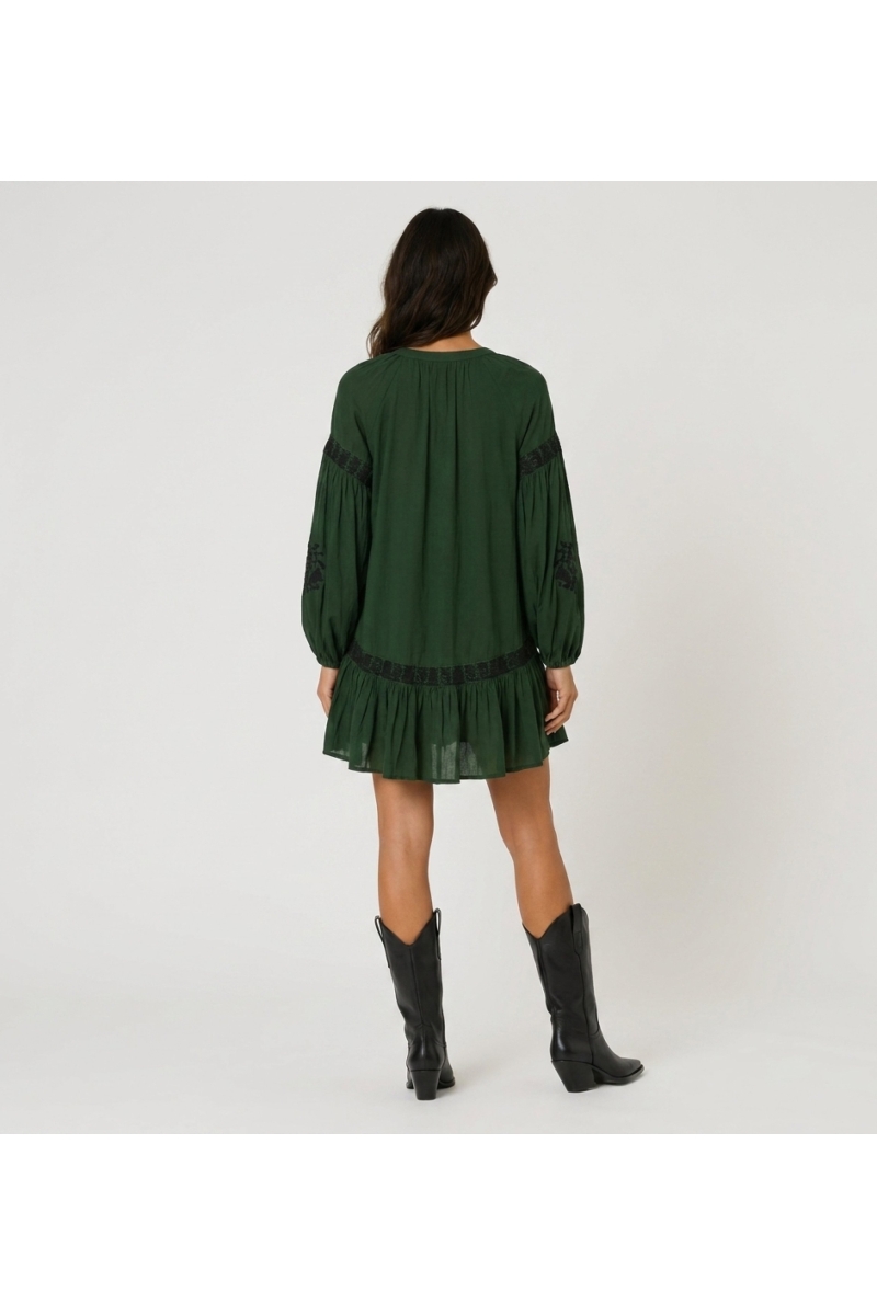 Miniabito verde scuro con colletto, ricamo floreale nero, vita annodata, maniche lunghe voluminose, vista posteriore.