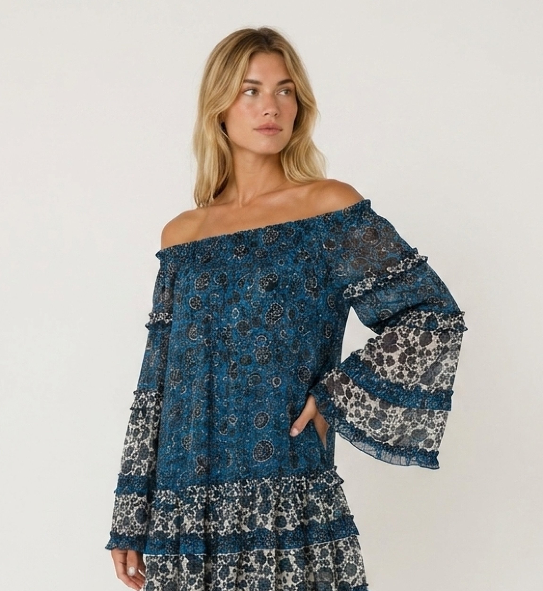 Blue and white off-shoulder mini dress with long sleeves, tiered ruffles, and sheer floral fabric.