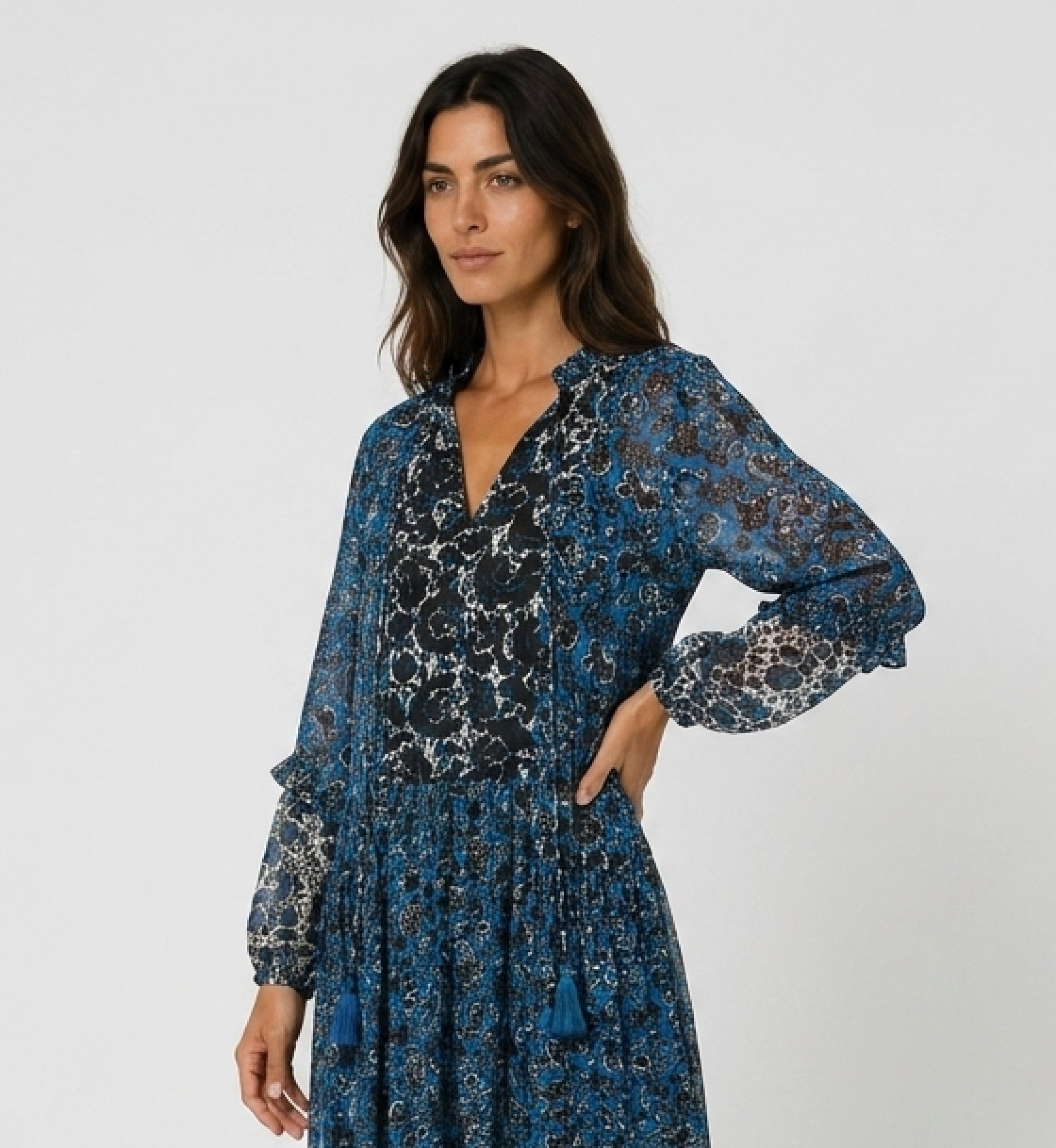 Three-quarter view of a long-sleeve tiered maxi dress with blue, black, white floral pattern, sheer fabric.