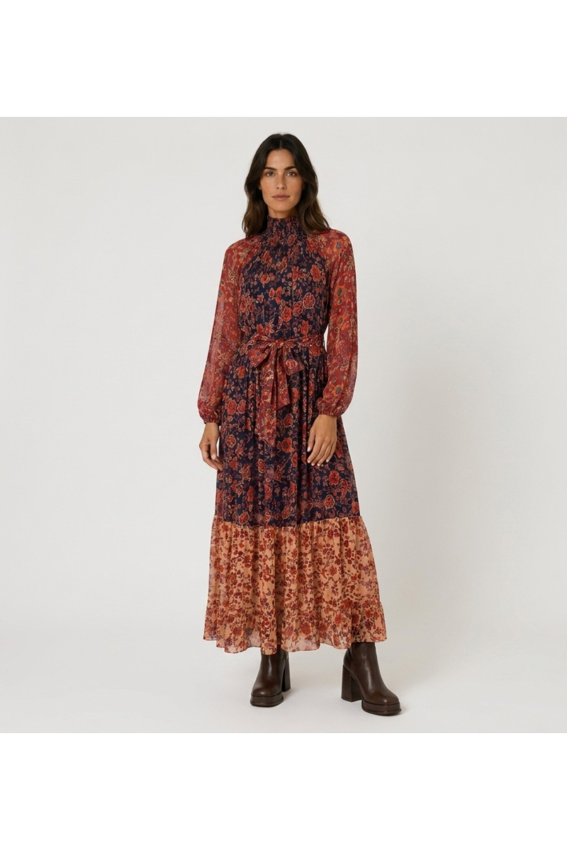 Front view of a sheer tiered maxi dress with floral pattern in red, orange & navy, smocked high neck & balloon sleeves.