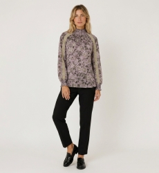 Lila Langarm-Bluse mit Stehkragen, dunklem Blumenmuster, beiger Spitze und gesmokten Ärmelbündchen, Vorderansicht.