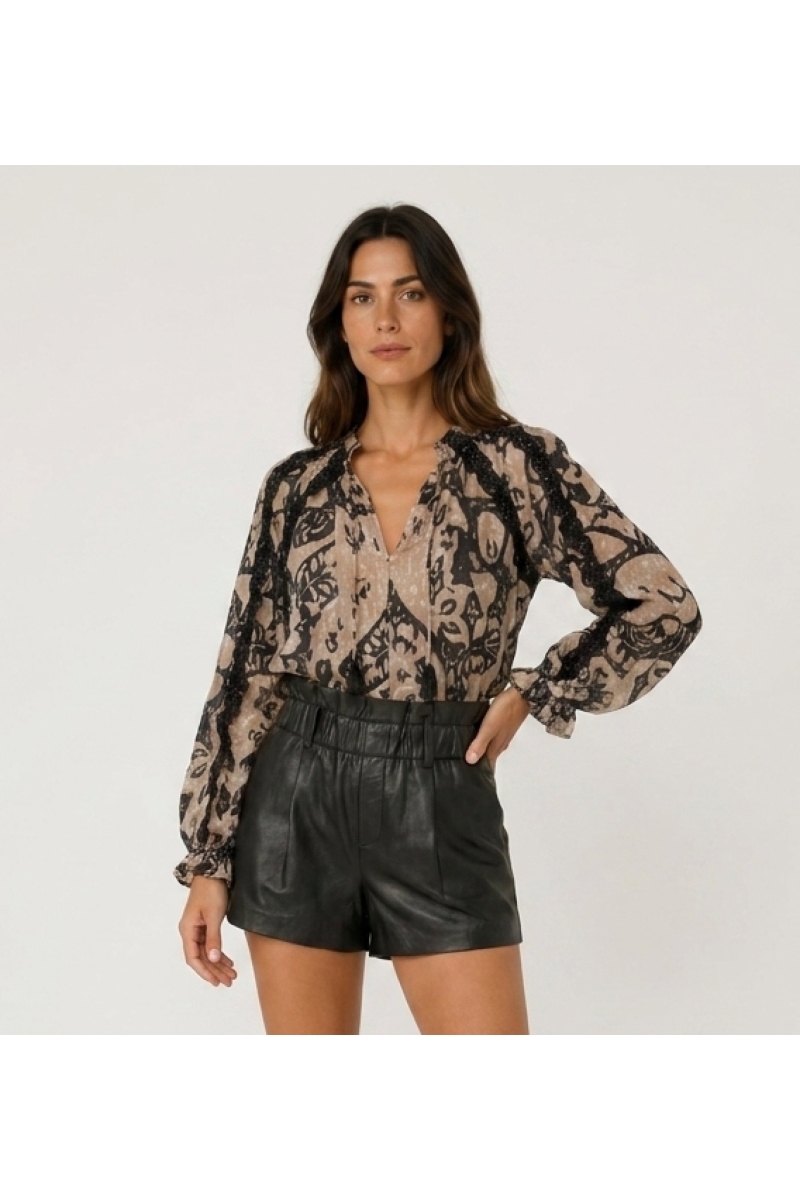 Black leather shorts, high elastic paperbag waist, loose wide leg. Three-quarter side view of stylish women's shorts.