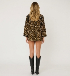 Rückenansicht einer lockeren schwarzen Bluse mit gold-weißem Leopardenmuster, Rüschenausschnitt und schwarzen Pompons mit Quaste