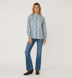 Blusa azzurra a maniche lunghe con fantasia paisley bianca, collo alto, abbottonatura frontale e polsini con volant.