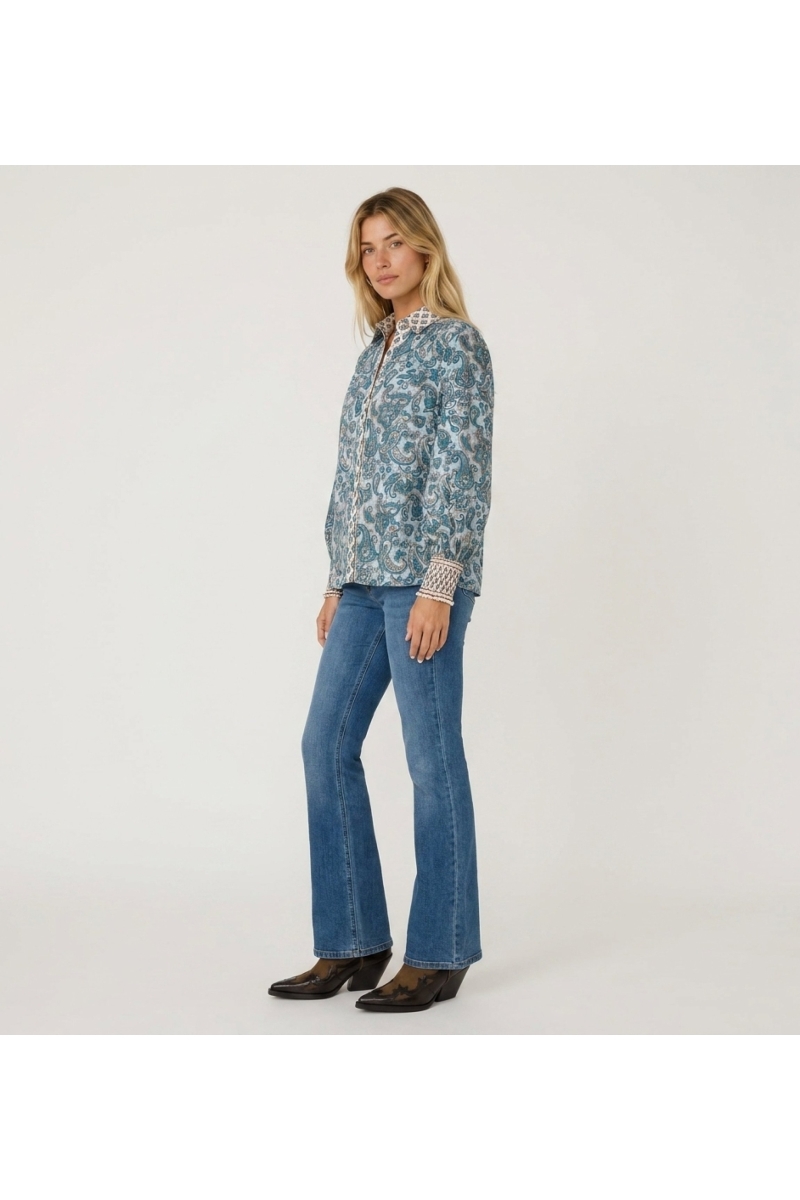Élégante chemise femme blanche coupe ample en tissu léger et fluide, vue de trois quarts. Idéale pour un style décontracté chic.