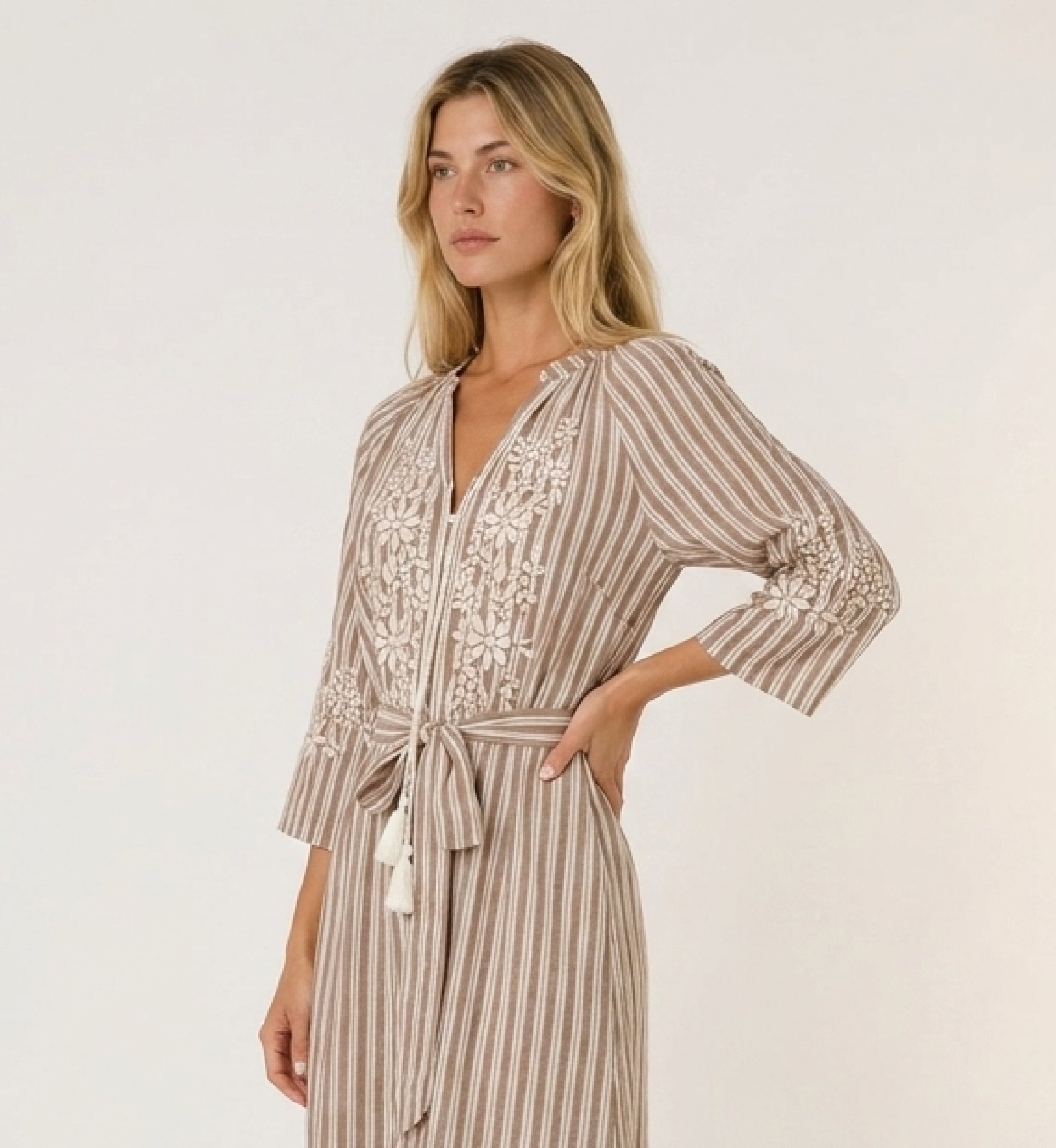 Braun-weiß gestreiftes Midikleid, Stufenrock, weiße Blumenstickerei, Bindegürtel mit Quasten, Dreiviertel-Ansicht.
