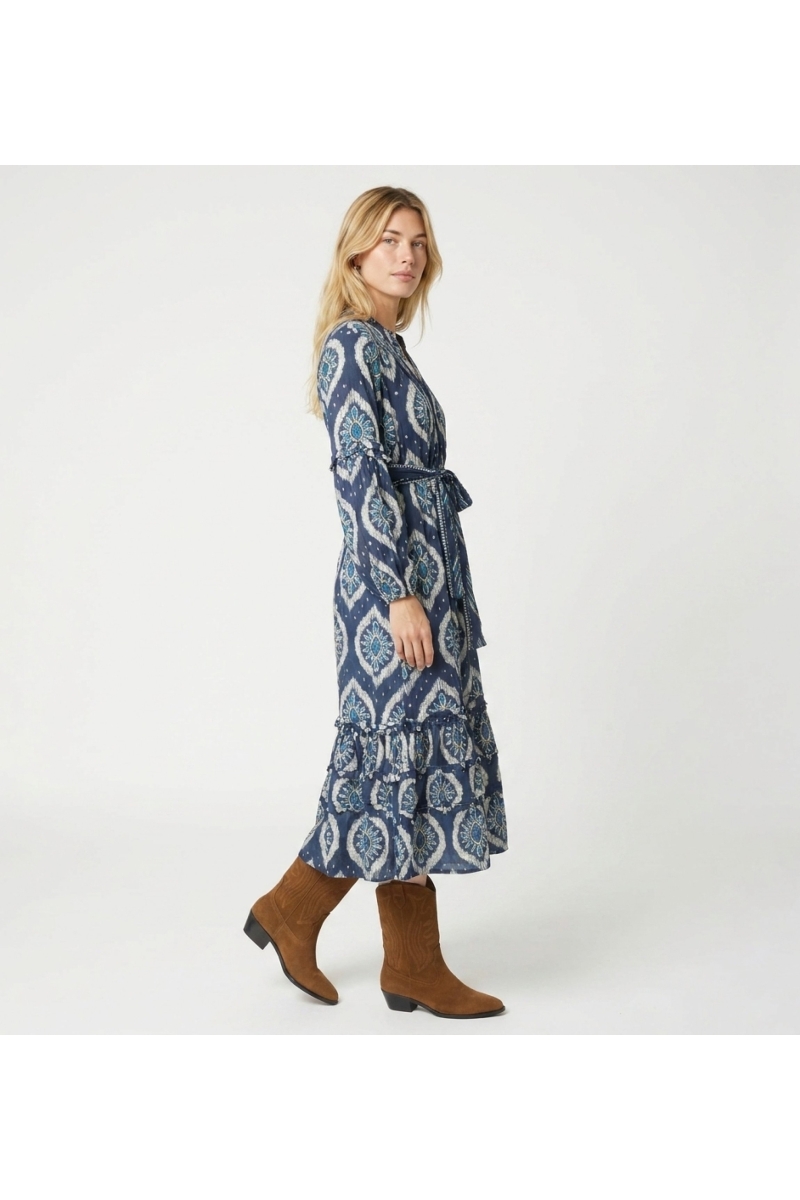 Blau-weißes Ikat-Midi-Kleid, lange Puffärmel, Stufenrock, Bindegürtel mit Quasten, Dreiviertel-Seitenansicht.
