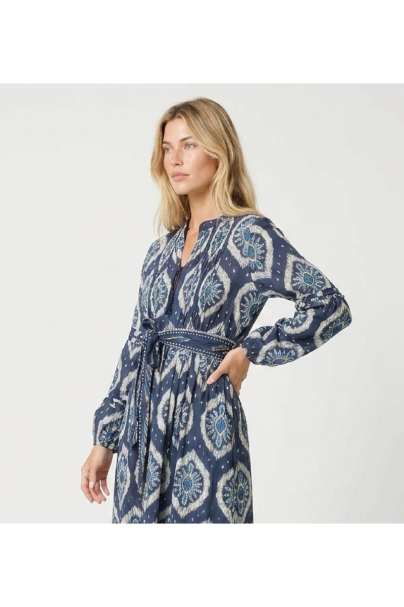 Abito midi ikat blu e bianco a maniche lunghe a sbuffo, gonna a balze e cintura coordinata, vista laterale.