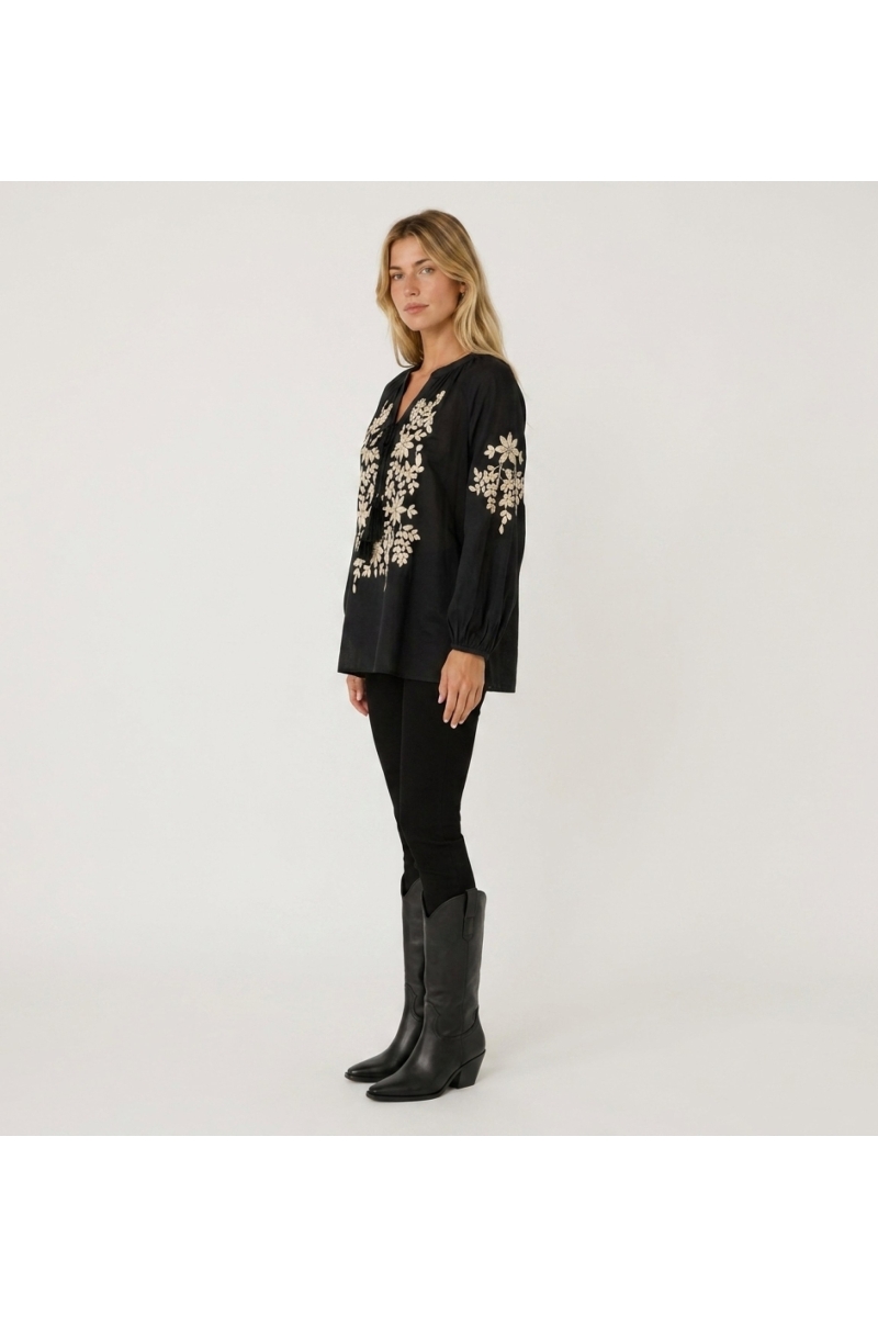 Schwarze Langarm-Bauernbluse mit V-Ausschnitt und Bindeband. Cremefarbene Blumenstickerei, Leinenoptik, 3/4-Ansicht.