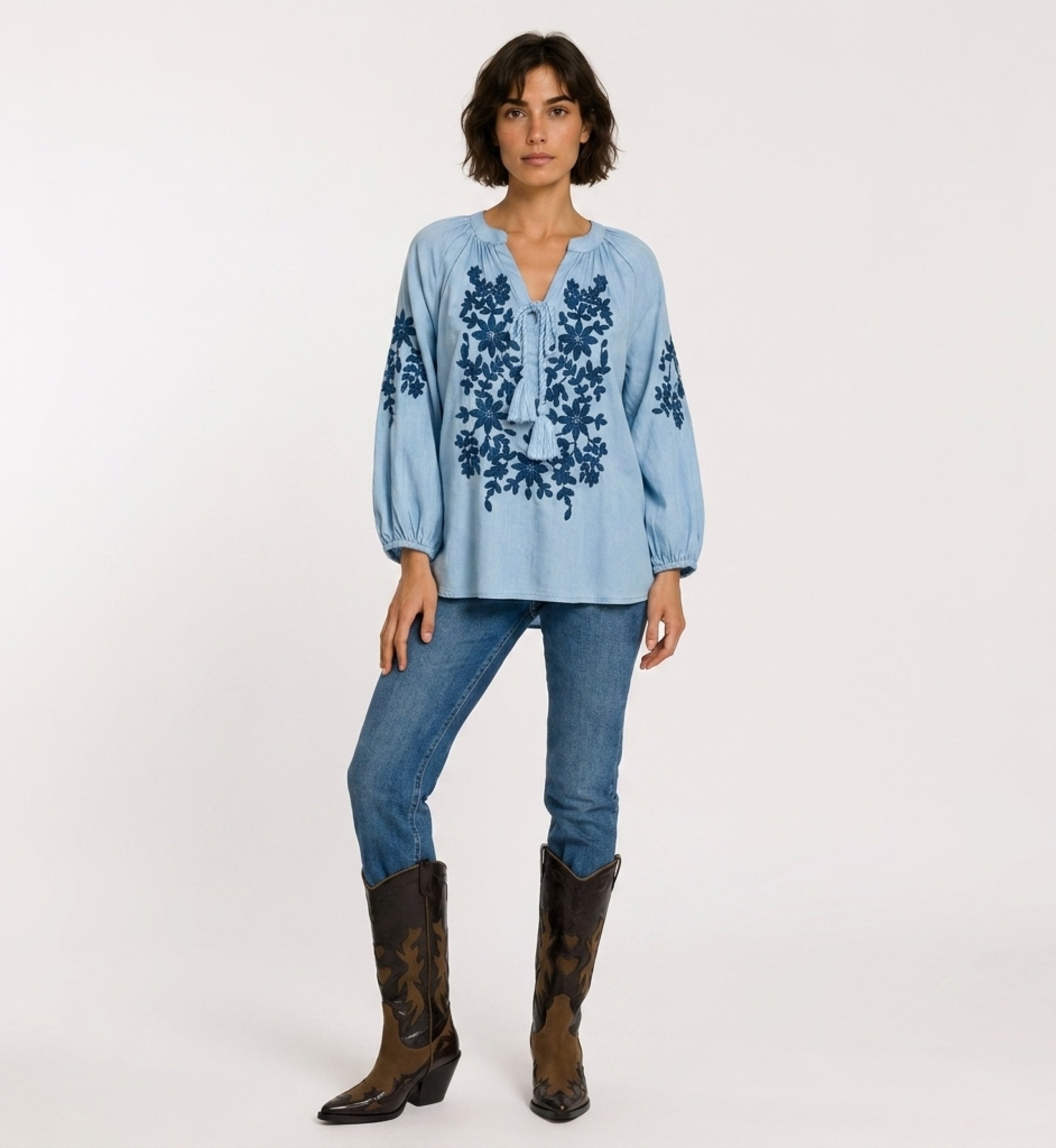 Blusa nera contadina a maniche lunghe, scollo a V con laccetto, ricamo floreale crema. Tessuto effetto lino, vista frontale.