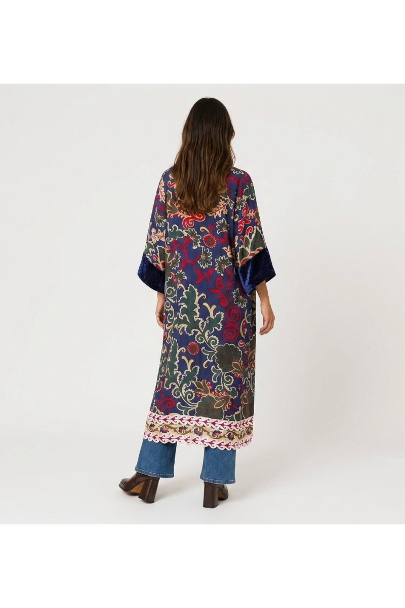 Vista traseira: quimono longo bordô solto, estampa floral paisley vibrante (rosa, amarelo, azul), acabamento veludo vermelho esc