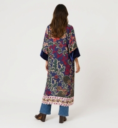Back view of a long burgundy kimono with vibrant pink, yellow, blue floral paisley pattern and dark red velvet trim. Loose fit.