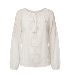 Blusa suelta color crema de manga larga con cuello de lazo y bordado, combinada con pantalón negro ancho.