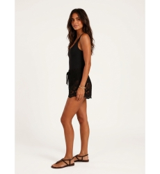 Short de crochet negro holgado, con intrincados patrones florales y hojas, cintura con cordón, en modelo de lado.