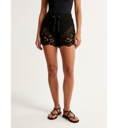 Nahaufnahme schwarzer Häkelshorts mit lockerem Schnitt, aufwendigen Blumen- und Blattmustern und Kordelzug in der Taille.